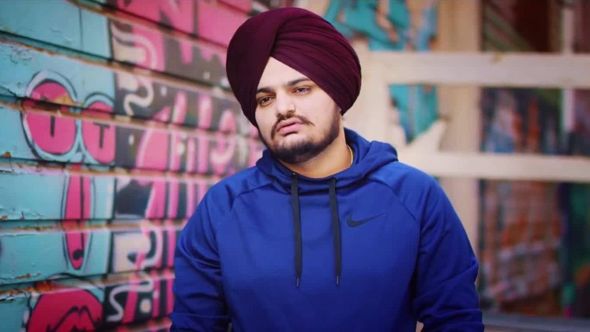 男子在塗鴉小巷中戴頭巾和連帽衫 — Sidhu Moose Wala 壁紙