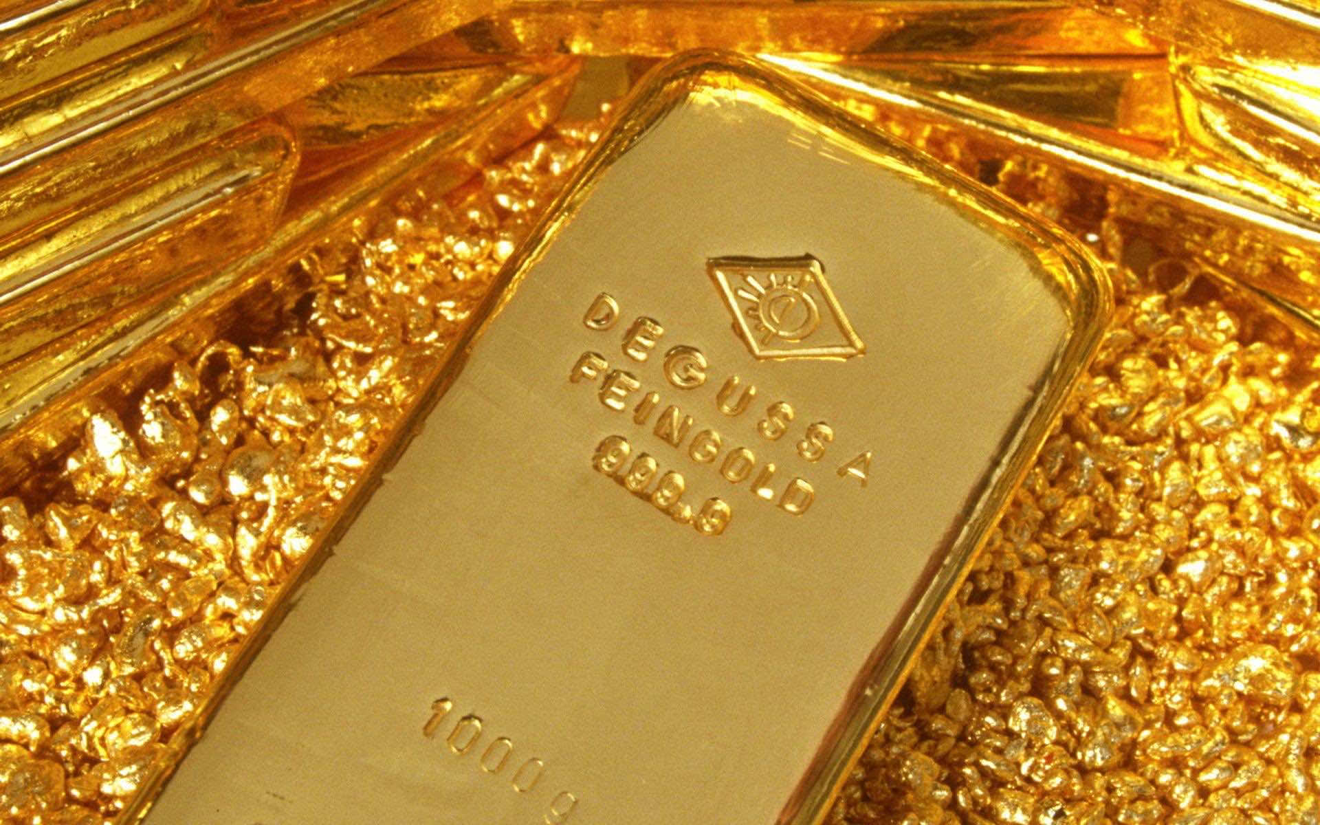 金色動態 桌布 壁紙 — 1000克Degussa金條的特寫，放置在閃閃發光的金片上，帶有銳利的反射。