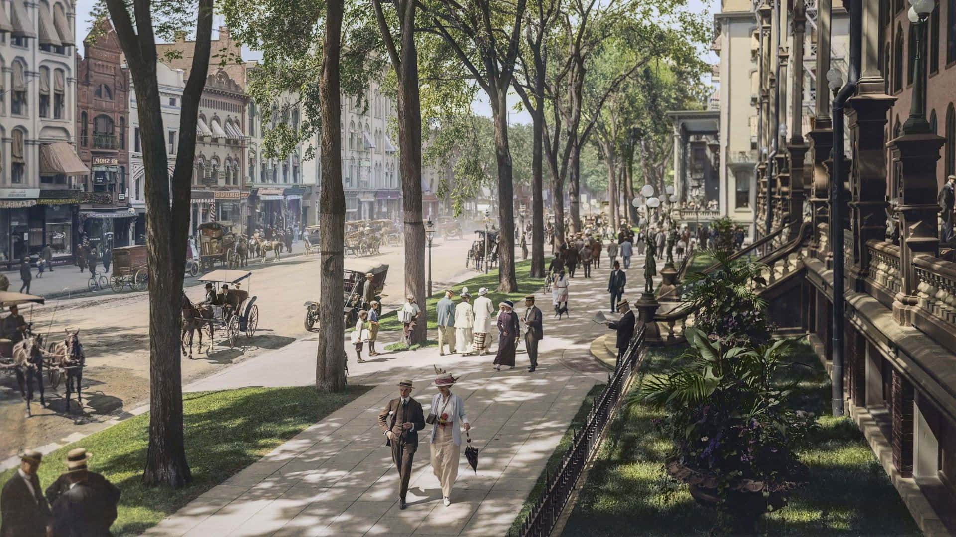 Old New York City 桌布 壁紙 — 1900年代初一條繁忙的綠樹成蔭的城市街道，有行人、馬車和華麗建築，在明亮的日光下。