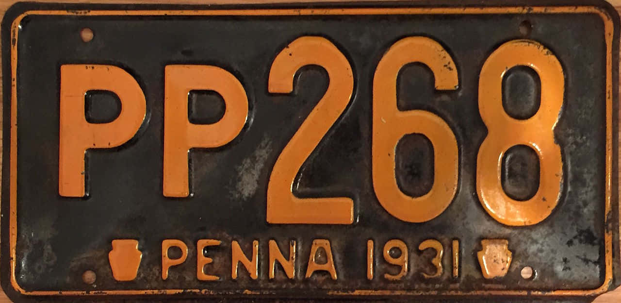 License Plate 桌布 壁紙 — 1931年賓夕法尼亞州復古車牌，黑色金屬上帶橙色字體，顯示磨損和鏽跡。