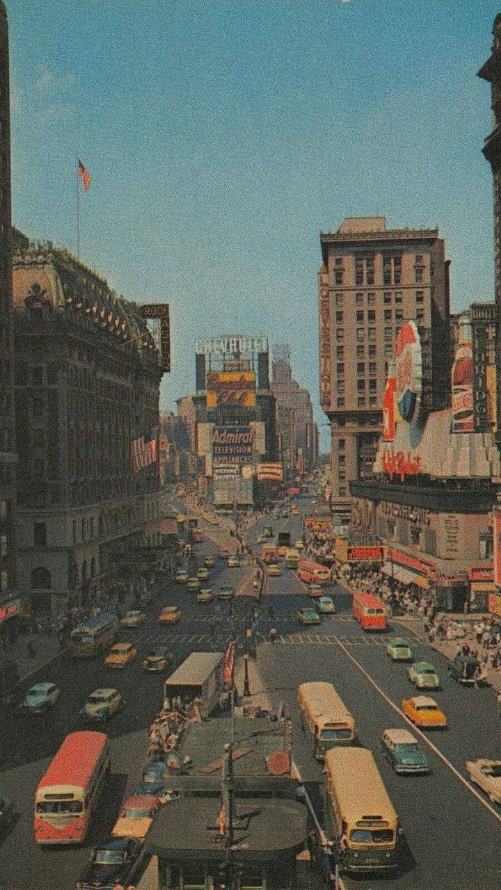 New York 桌布 壁紙 — 1950年代紐約市復古街道，充滿經典汽車、巴士和高聳的廣告牌，在清澈的藍天下。