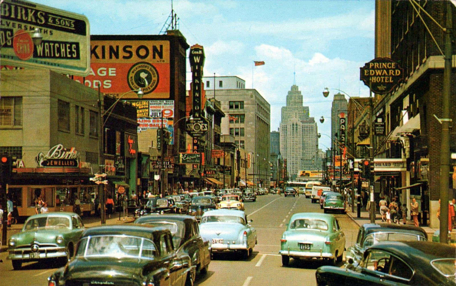 1970s 桌布 壁紙 — 1950年代繁華的城市街道， vintage 汽車和色彩繽紛的商店櫥窗在明亮的藍天下。