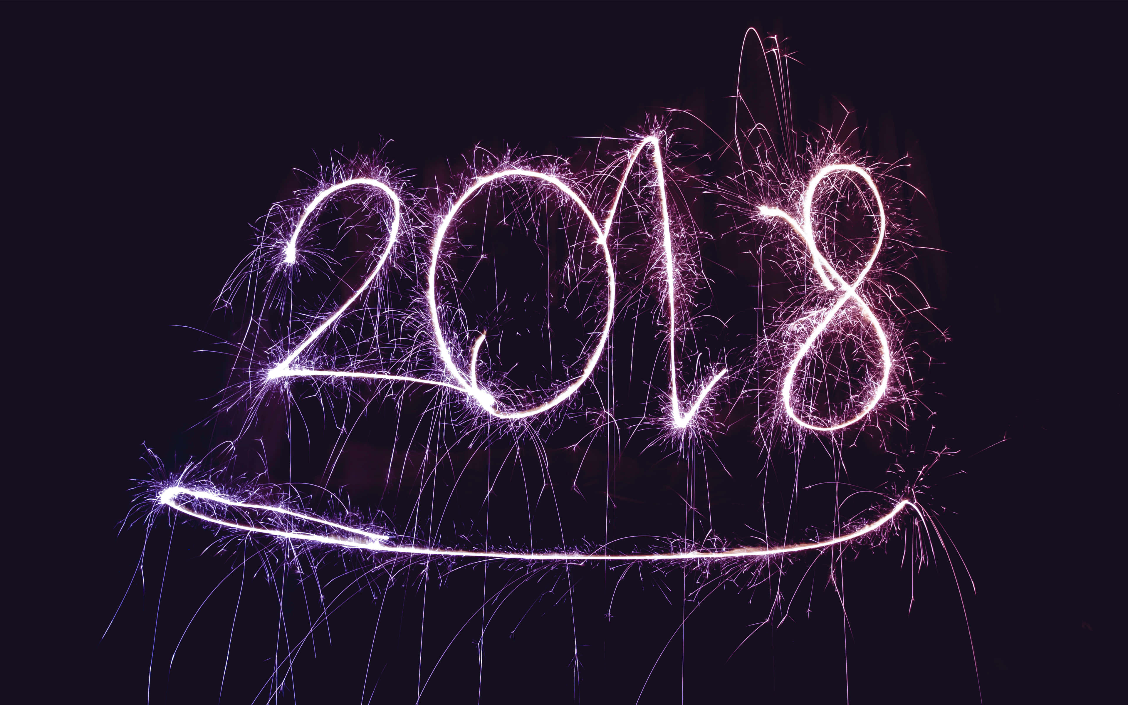 2018 桌布 壁紙 — 2018年以發光的紫色煙火書寫，在黑暗的夜空背景下，帶有拖尾的火花。
