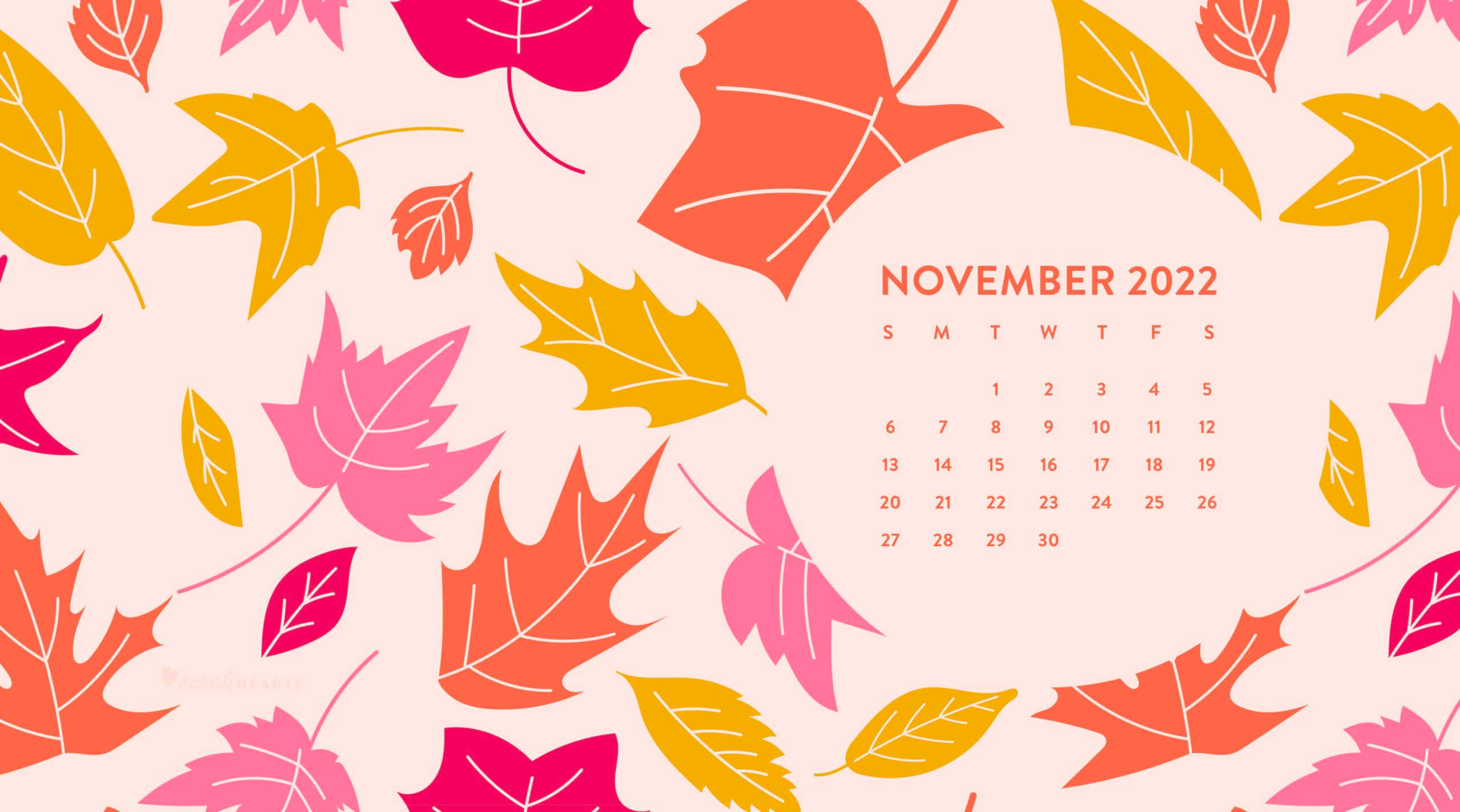 十一月 桌布 壁紙 — 2022年11月月曆，周圍環繞著風格化的粉紅色、黃色和橙色秋葉，背景為柔和的粉紅色。