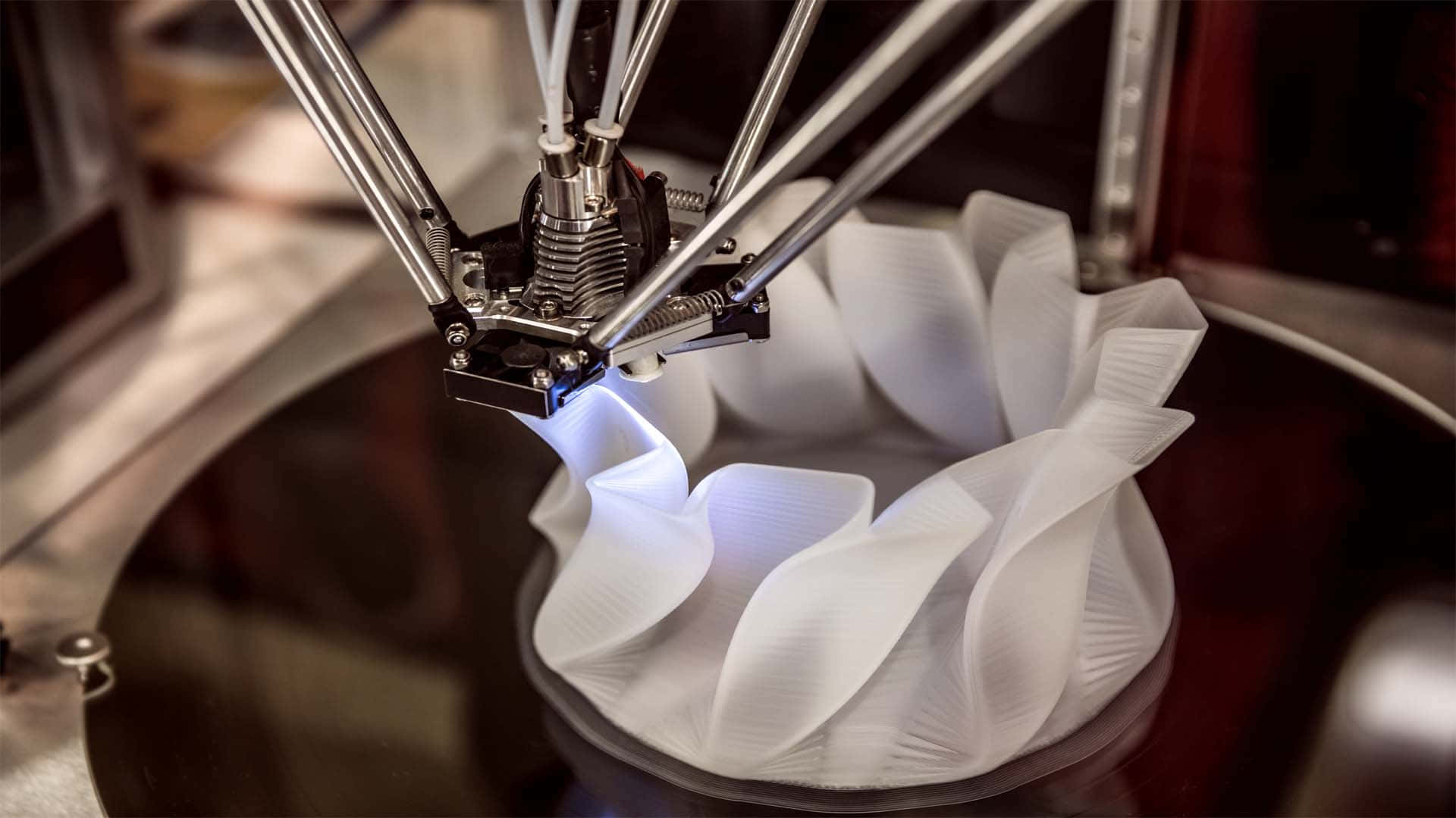 3d Printer 桌布 壁紙 — 3D列印機擠出白色線材形成帶有藍色發光的分層有機形狀的特寫。