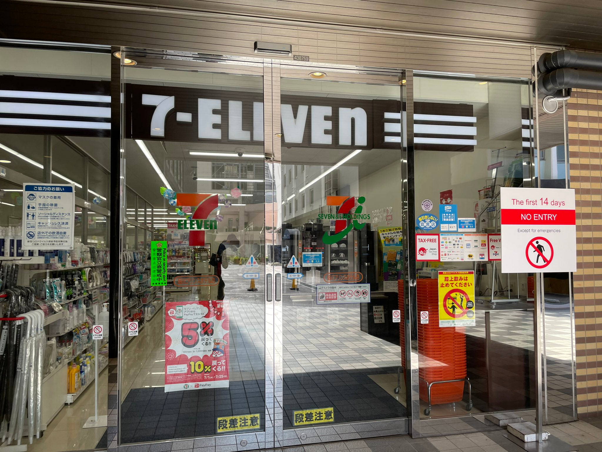 Eleven 桌布 壁紙 — 7-Eleven 店舖入口，玻璃門上展示宣傳標誌及前14天的「禁止進入」告示。