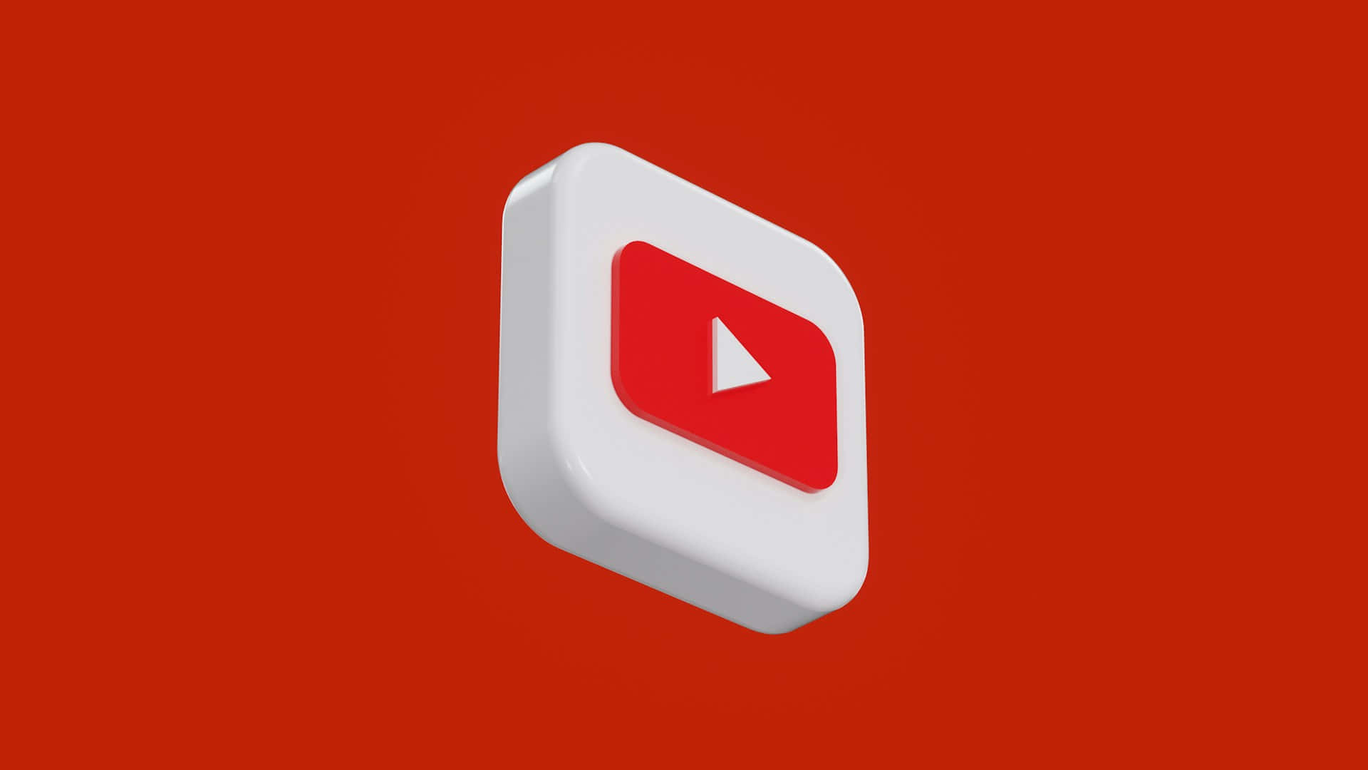  壁紙 — 一個3D渲染的YouTube播放按鈕圖示漂浮在純紅色背景上，帶有柔和陰影。