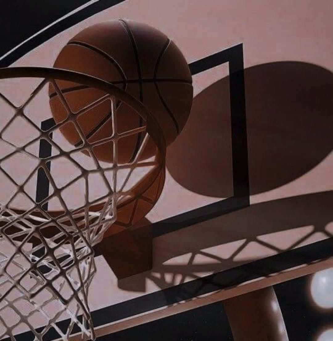  壁紙 — 一個籃球在半空中穿過籃框，在蜜桃色籃板上投下戲劇性的陰影。