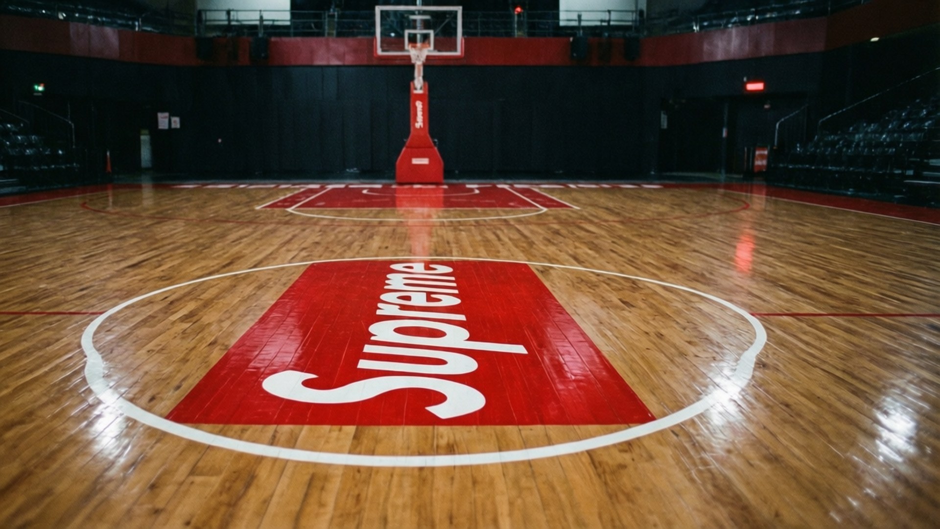 Supreme Basketball Court 壁紙 — 一個籃球場，木地板上有一個大型紅色Supreme標誌，位於籃框下方。