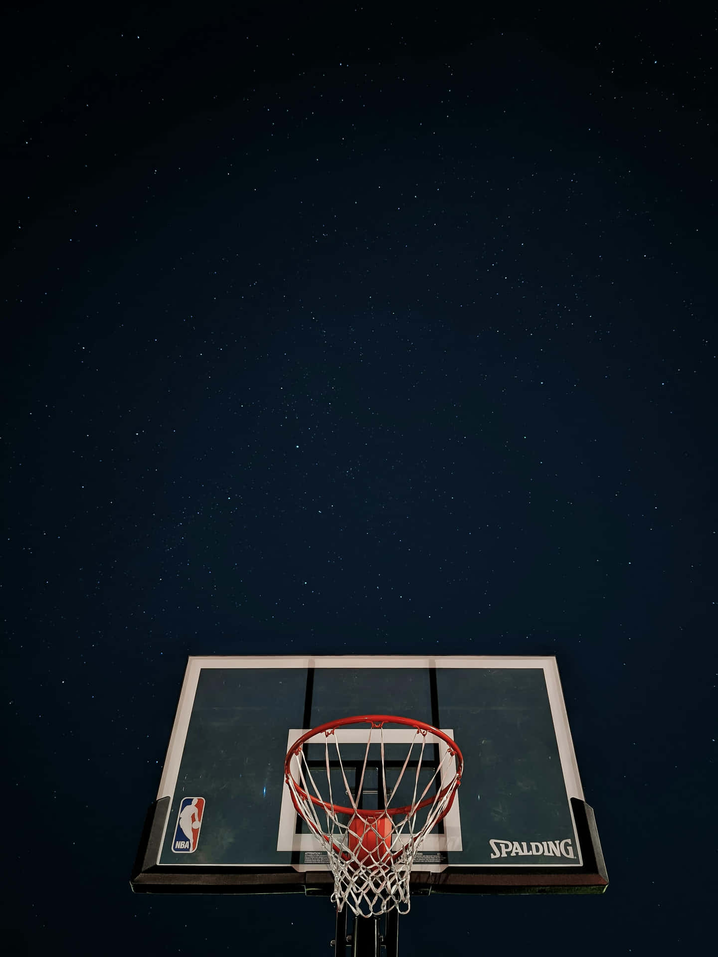  壁紙 — 在星空下的籃球框，帶有紅色籃圈和 Spalding 籃板。