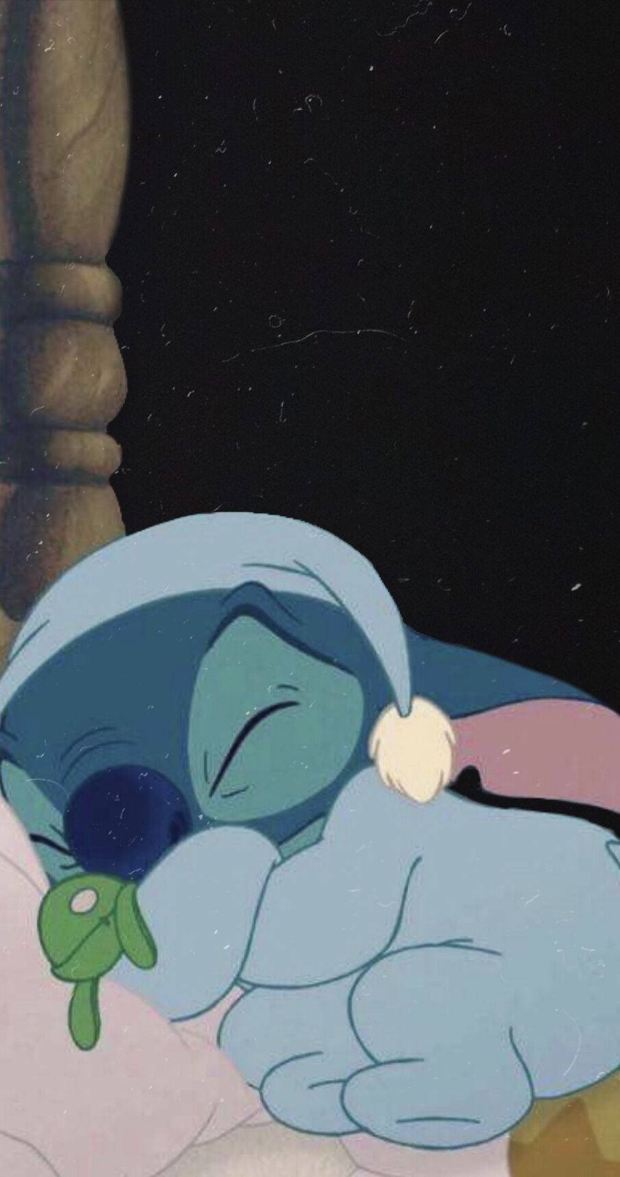 一個藍色外星人帶著奶嘴和睡帽在床上睡覺。 — Stitch 壁紙