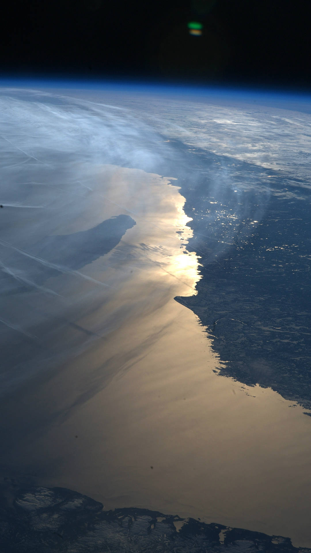 從太空看地球，陽光反射在海岸線附近的海洋水面上。 — 地球 壁紙
