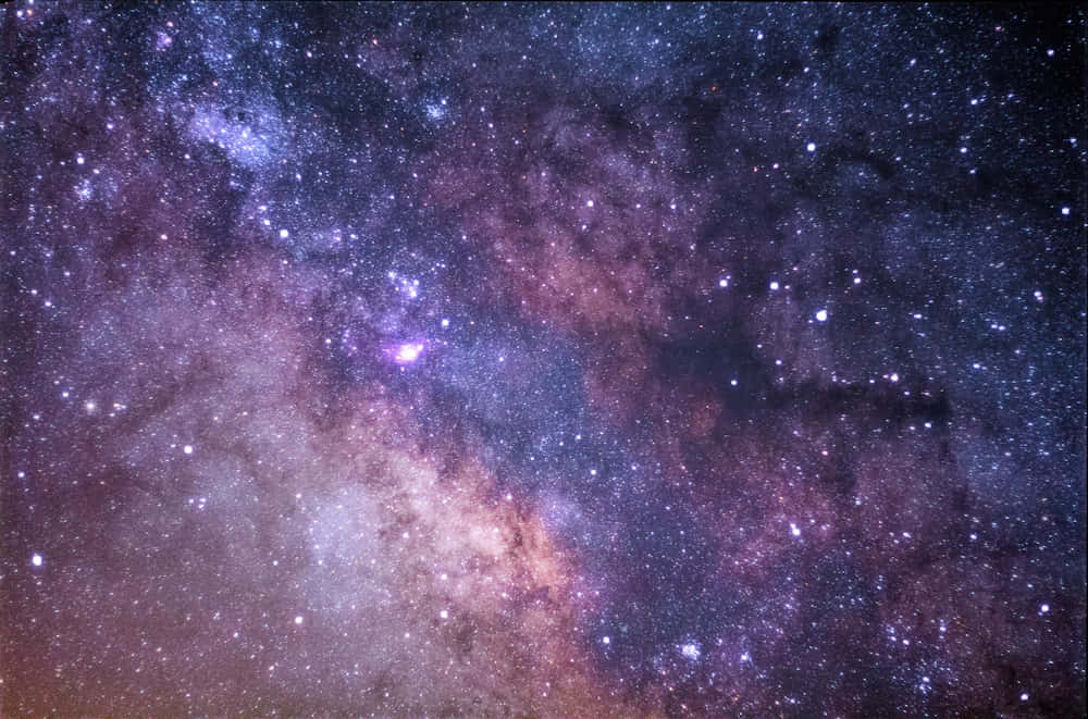 壁紙 — 令人嘆為觀止的銀河系景觀，紫色和粉紅色的星雲在繁星點點的宇宙背景下閃耀。