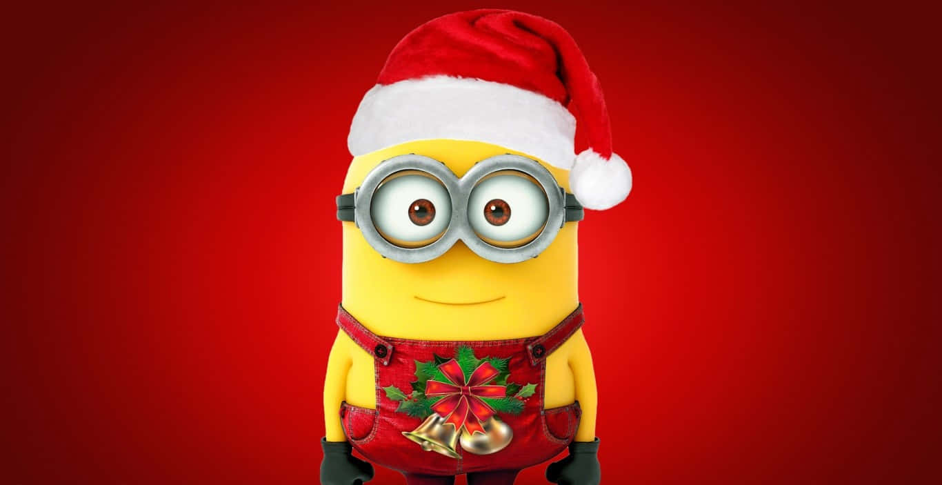  壁紙 — 一個戴著聖誕帽和節日吊帶褲的開心黃色Minion站在鮮豔的紅色背景前。