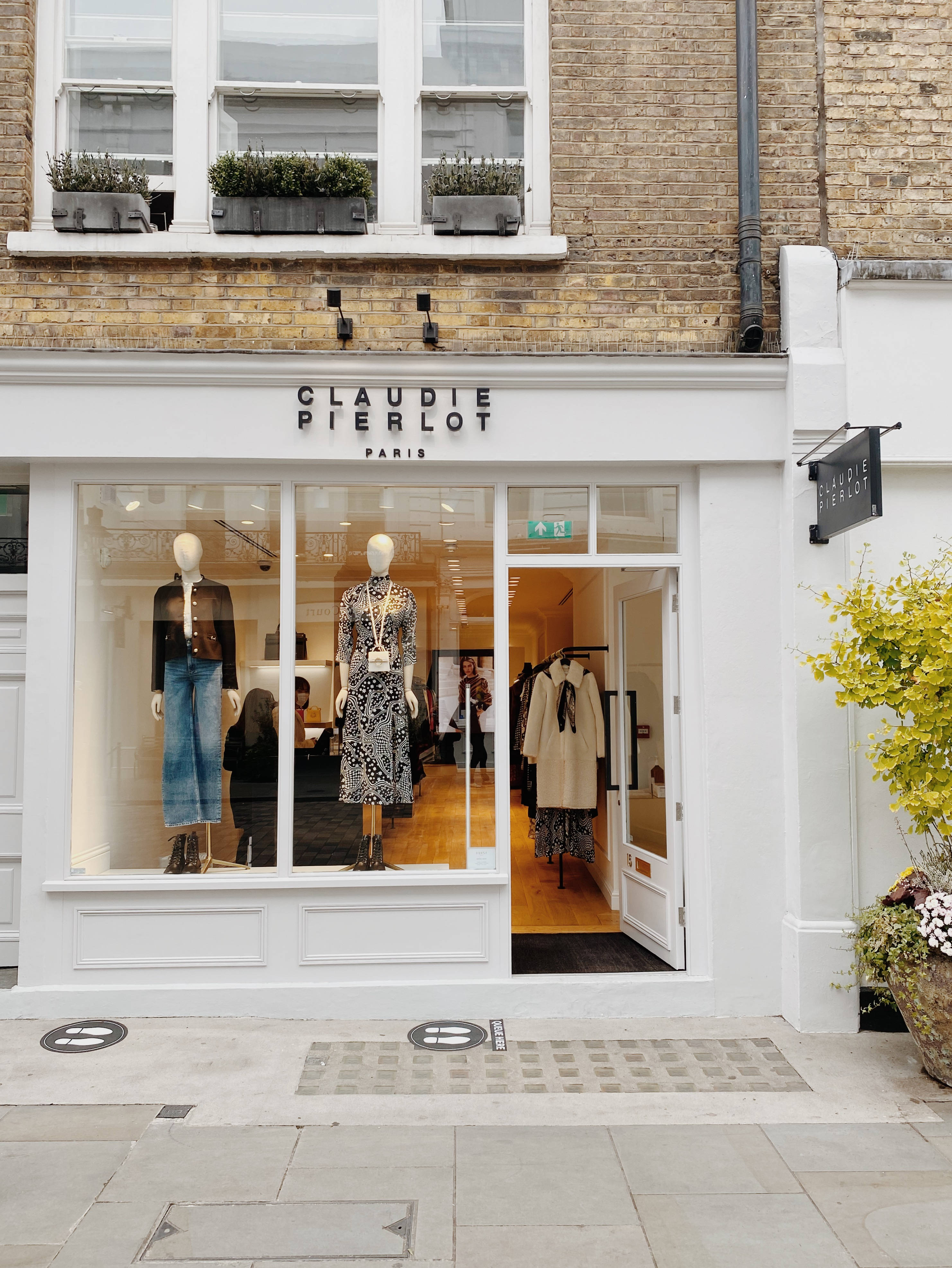 Store 桌布 壁紙 — Claudie Pierlot Paris 精品店的別緻白色外牆，明亮的櫥窗中展示著穿著時尚服裝的人體模型。
