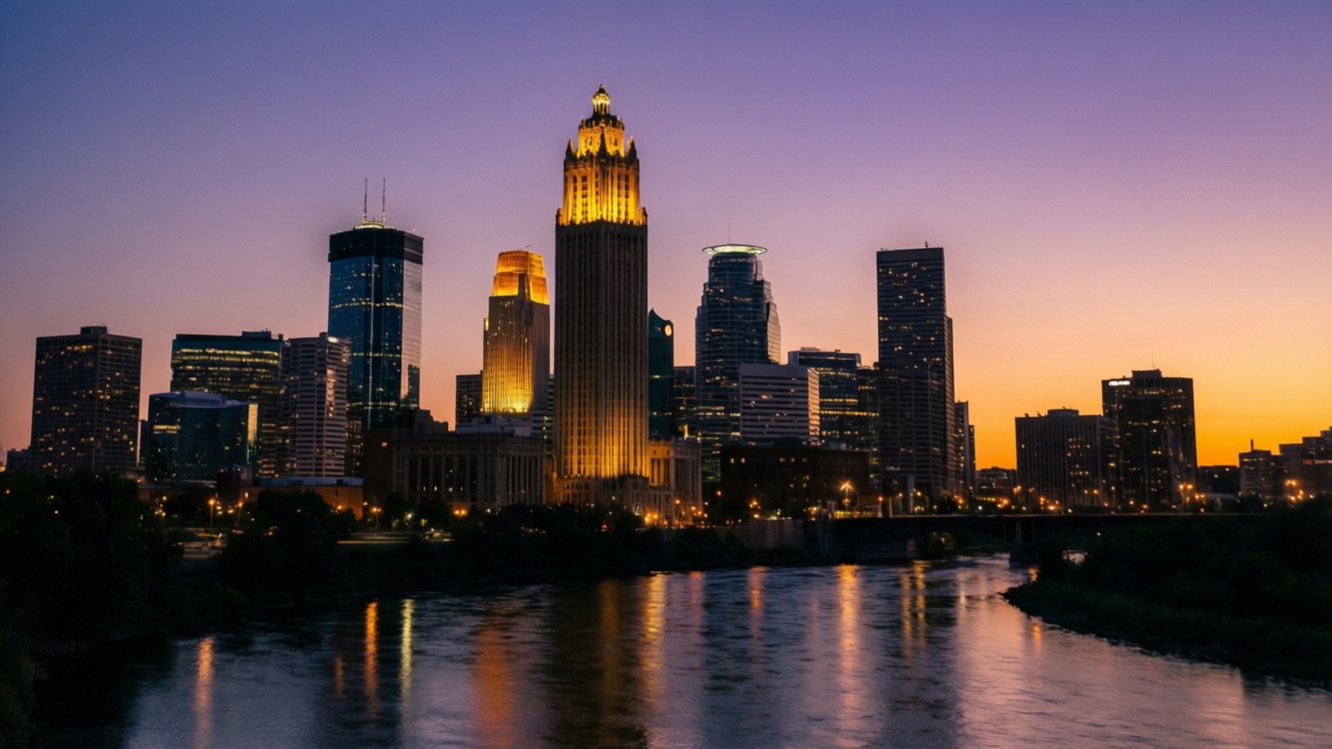 Minneapolis Skyline Dusk 壁紙 — 黃昏時分的城市天際線，金色摩天大樓在平靜的河流中倒映，天空呈現紫橙色。