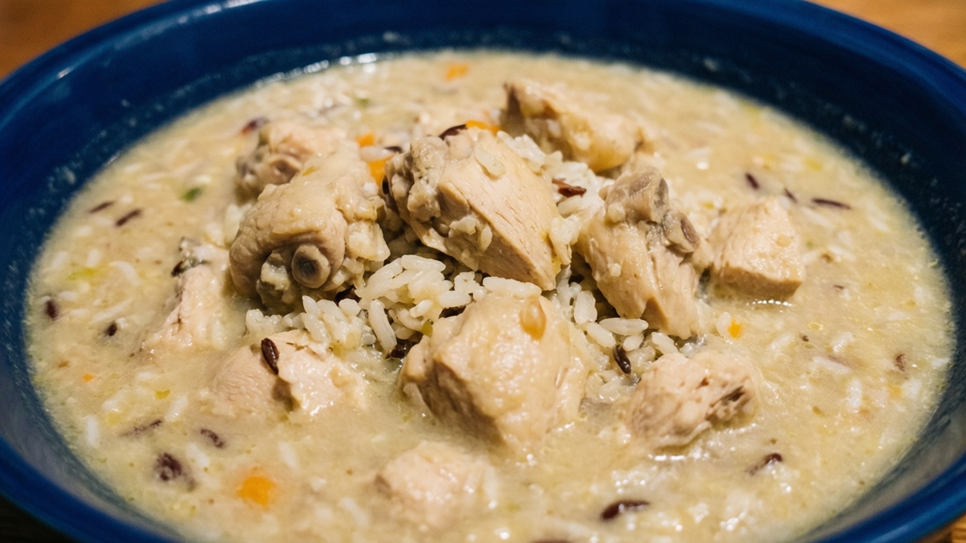 Chicken Wild Rice Chowder 壁紙 — 一個藍色碗的特寫，裡面裝滿了奶油雞肉和米飯燉菜，可見嫩雞肉和野生米粒。