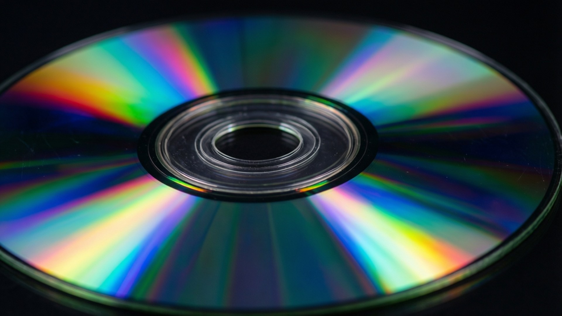 Dvd 桌布 壁紙 — 黑色背景上反射出鮮豔彩虹色的CD特寫。