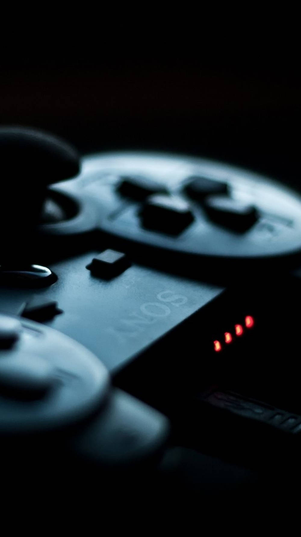 遊戲 桌布 壁紙 — Sony PlayStation 控制器在黑暗背景中發出紅光的特寫。