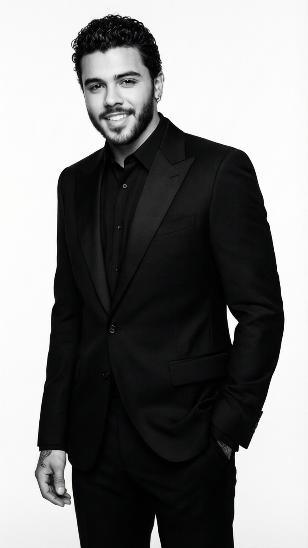 Black Suit Portrait 壁紙 — 一位自信的男人穿著一套銳利的黑色西裝，在純白背景前溫暖地微笑。