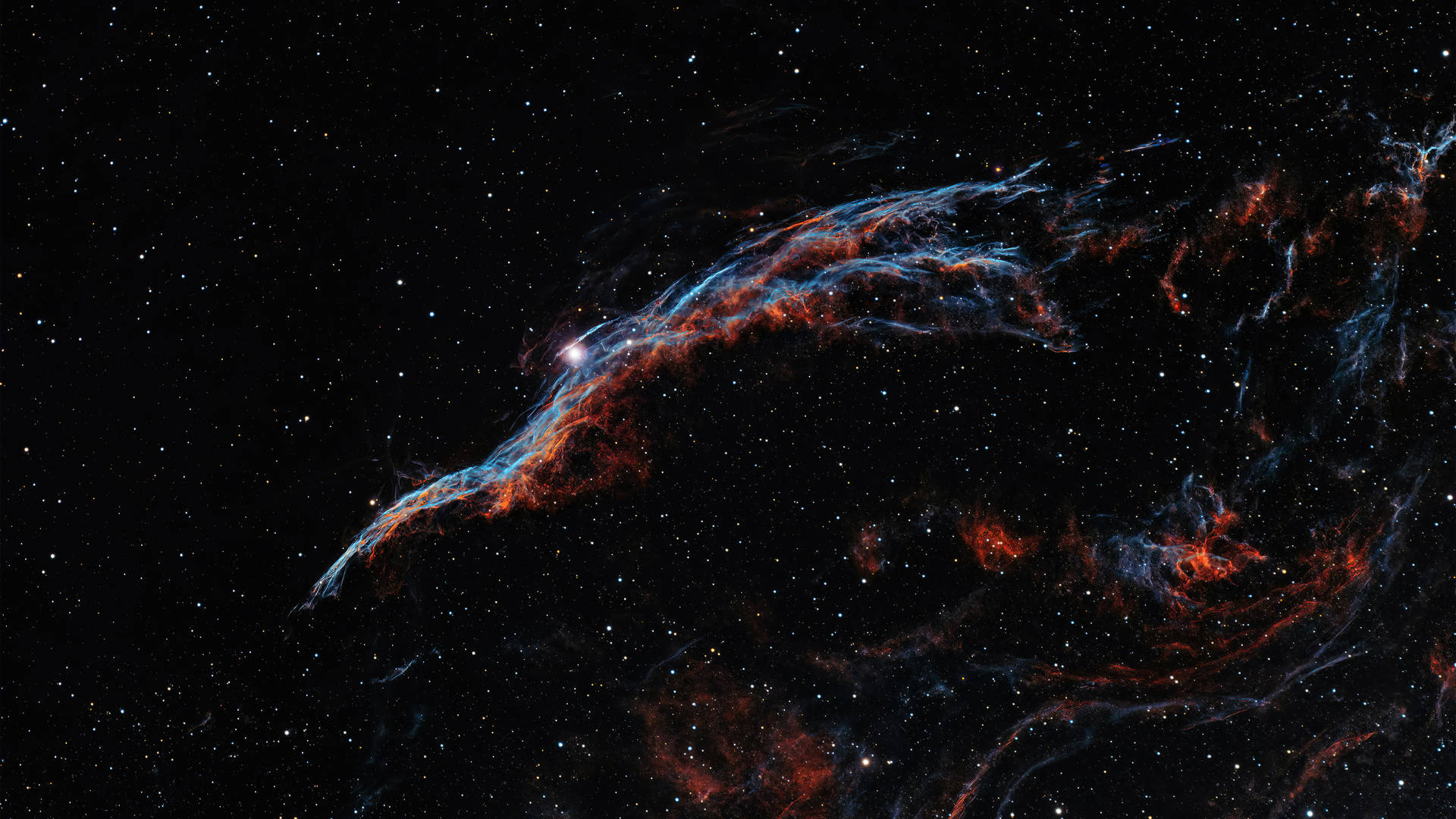 在深空中，鮮豔的紅色和藍色星雲在遙遠的星星之間發光。 — 4K 壁紙
