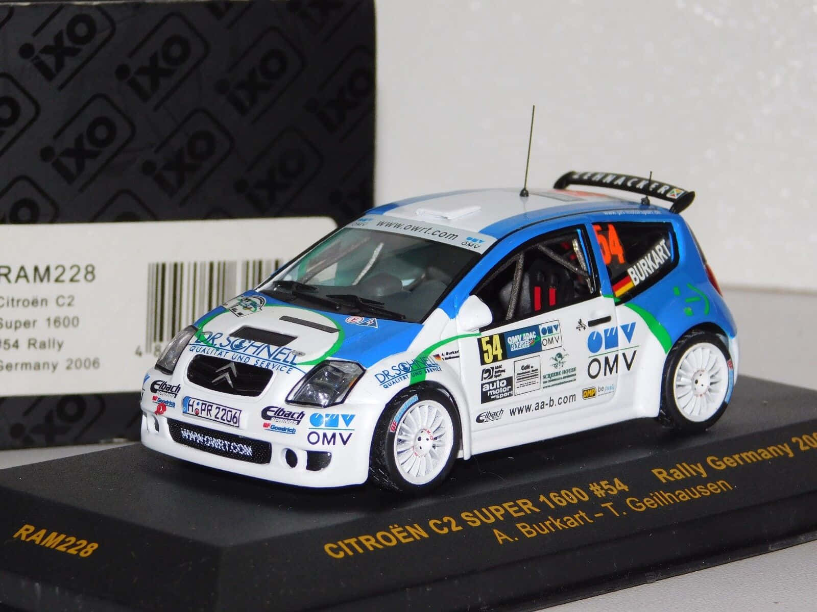 Citroen C2 Super 1600 桌布 壁紙 — 一輛藍白色雪鐵龍C2拉力賽車（編號54）的精細比例模型，展示在帶有品牌標誌的黑色底座上。