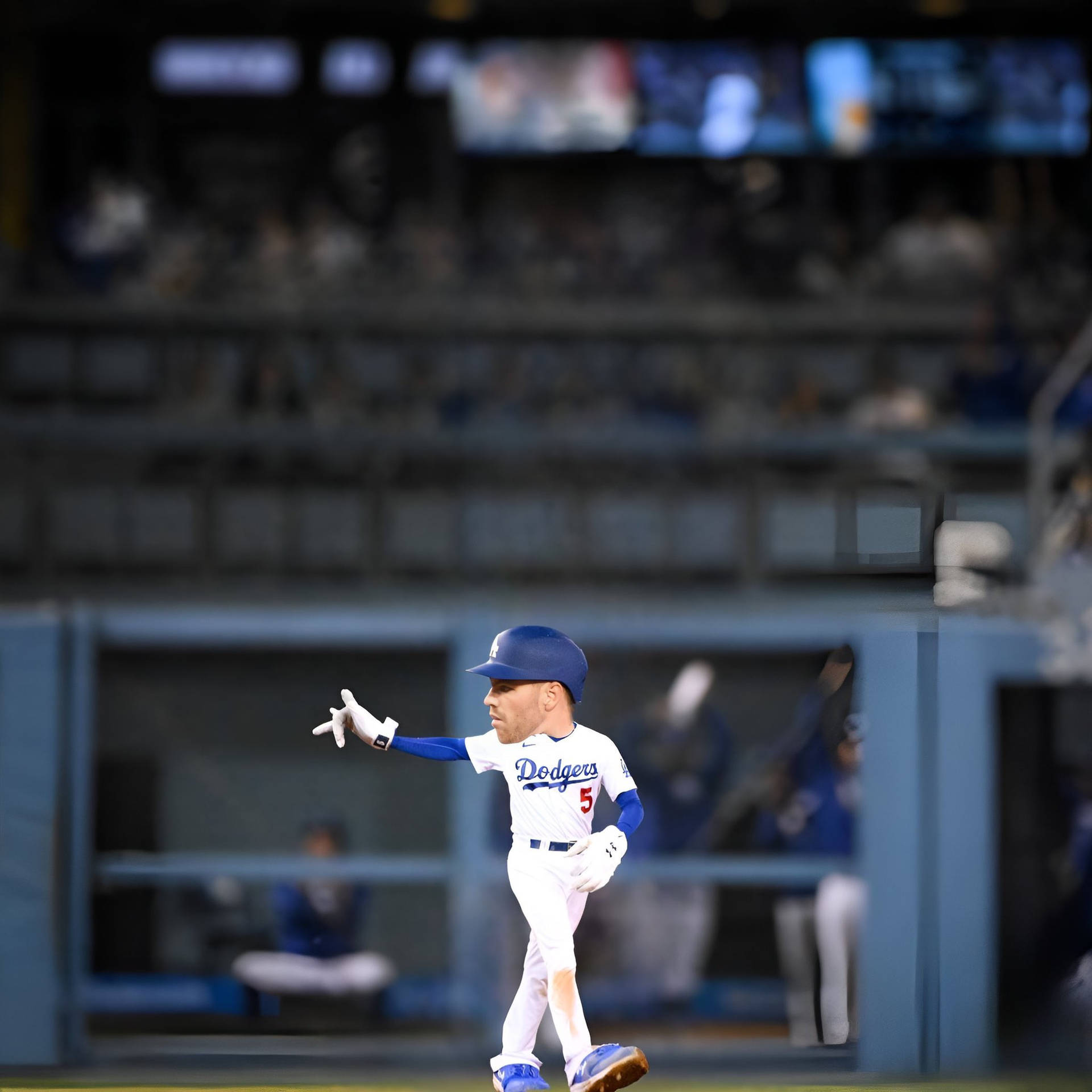 身穿道奇隊球衣的棒球選手在夜間球場上做手勢。 — MLB 壁紙