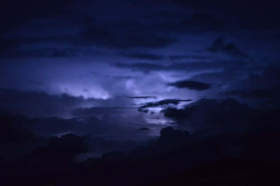  壁紙 — 充滿烏雲的戲劇性夜空，被鮮豔的紫色閃電照亮。