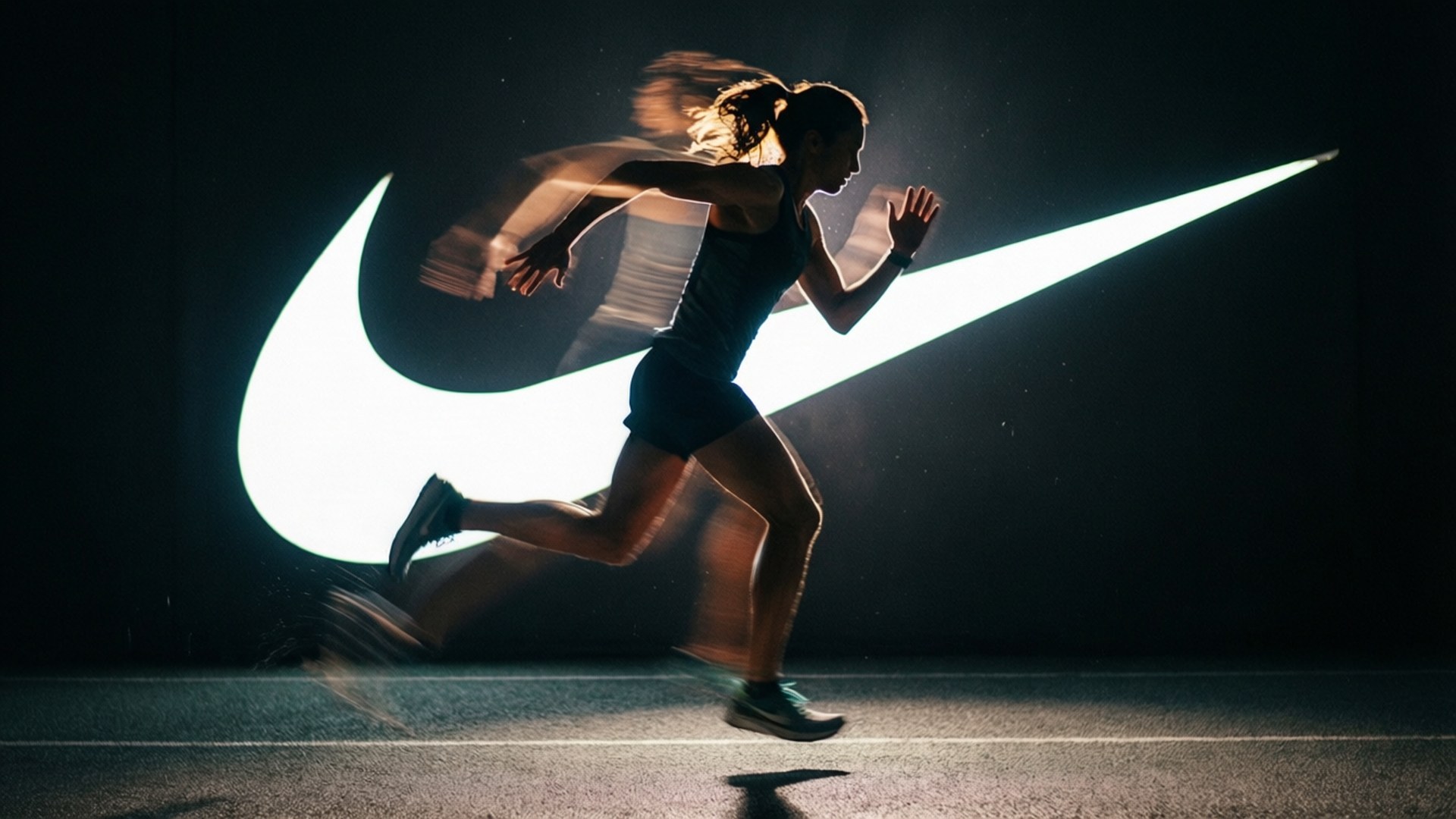 Athletic Silhouette 壁紙 — 一名女性跑者正在移動中，在黑暗背景前疾馳而過一個發光的Nike勾號標誌。