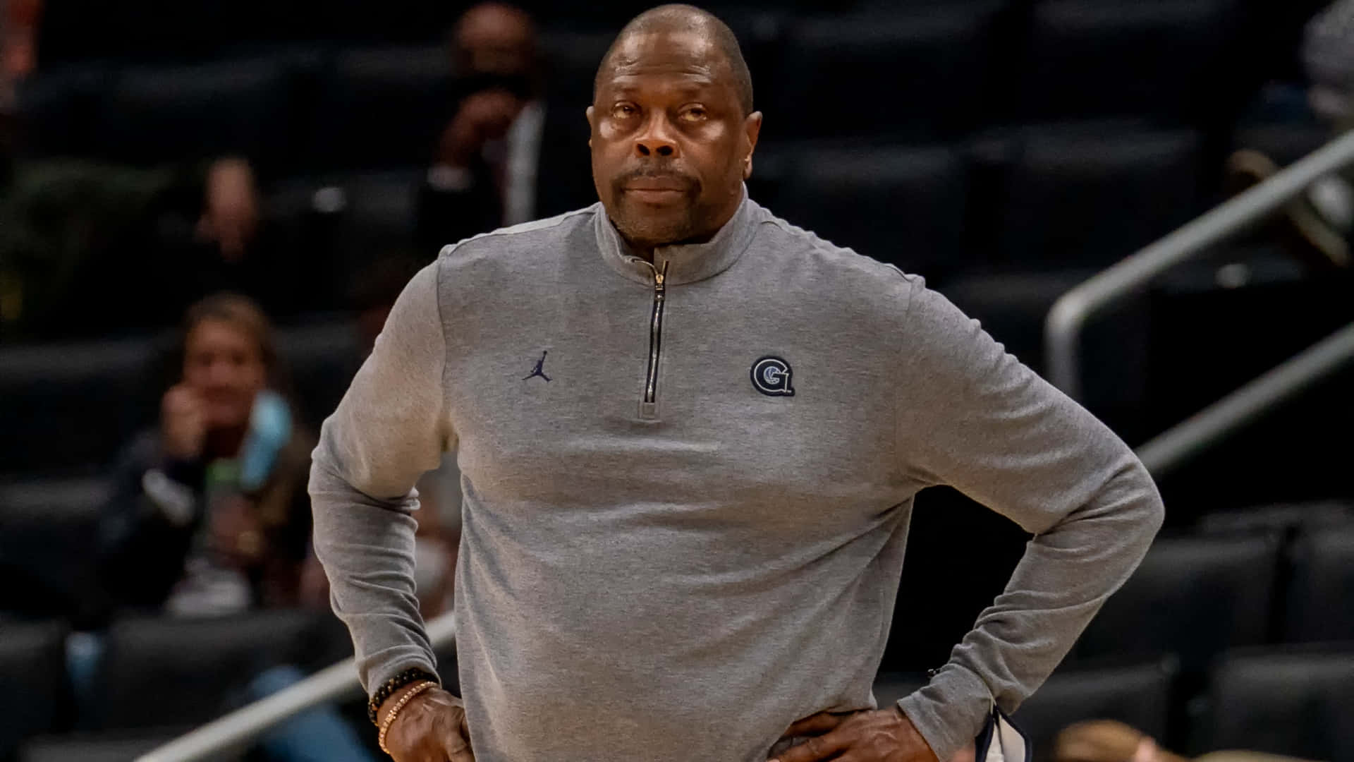籃球教練在場館內雙手叉腰站立。 — NBA 壁紙