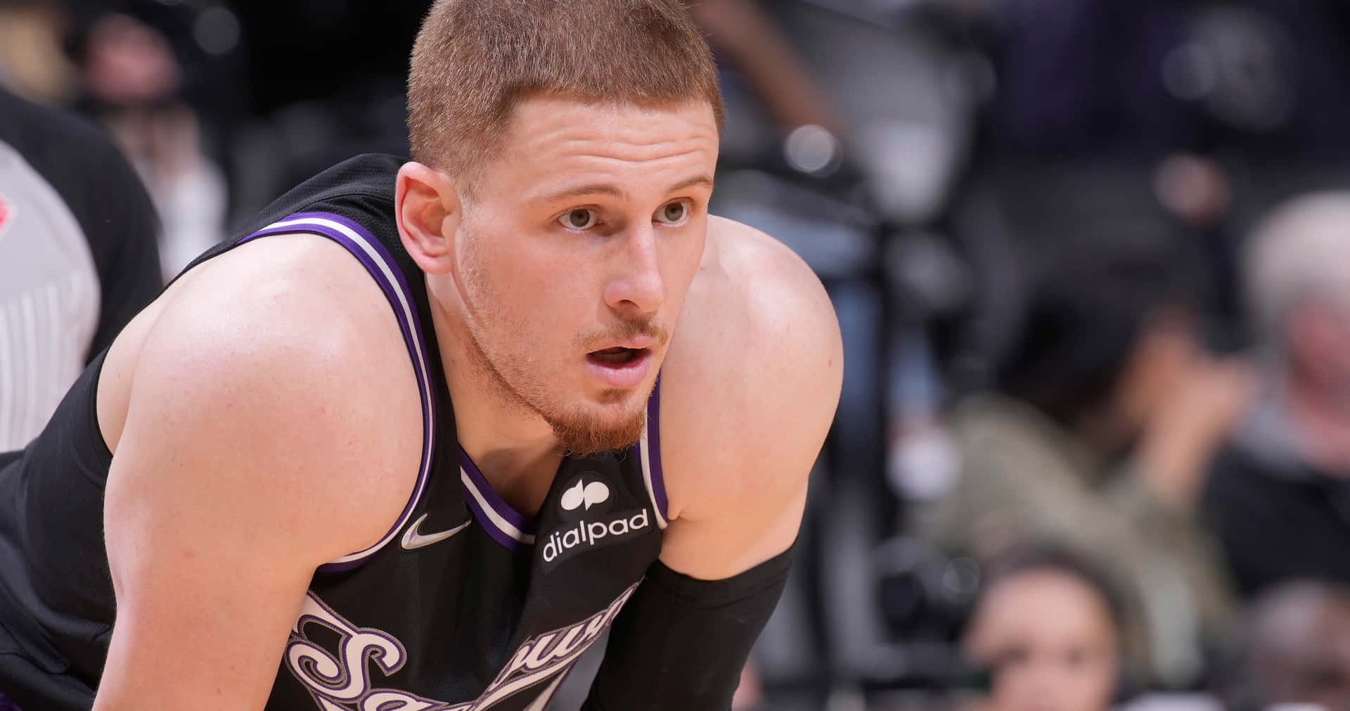 身穿黑色和紫色球衣的籃球運動員在比賽中高度專注。 — NBA 壁紙