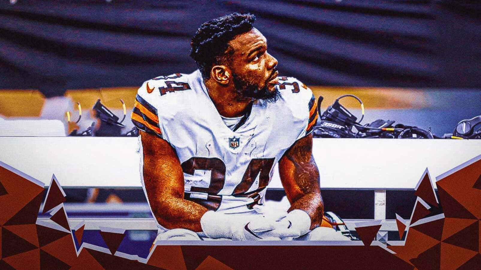  壁紙 — 一位專注的NFL球員身穿白色球衣坐在長椅上，底部有幾何紅棕色圖案框住。