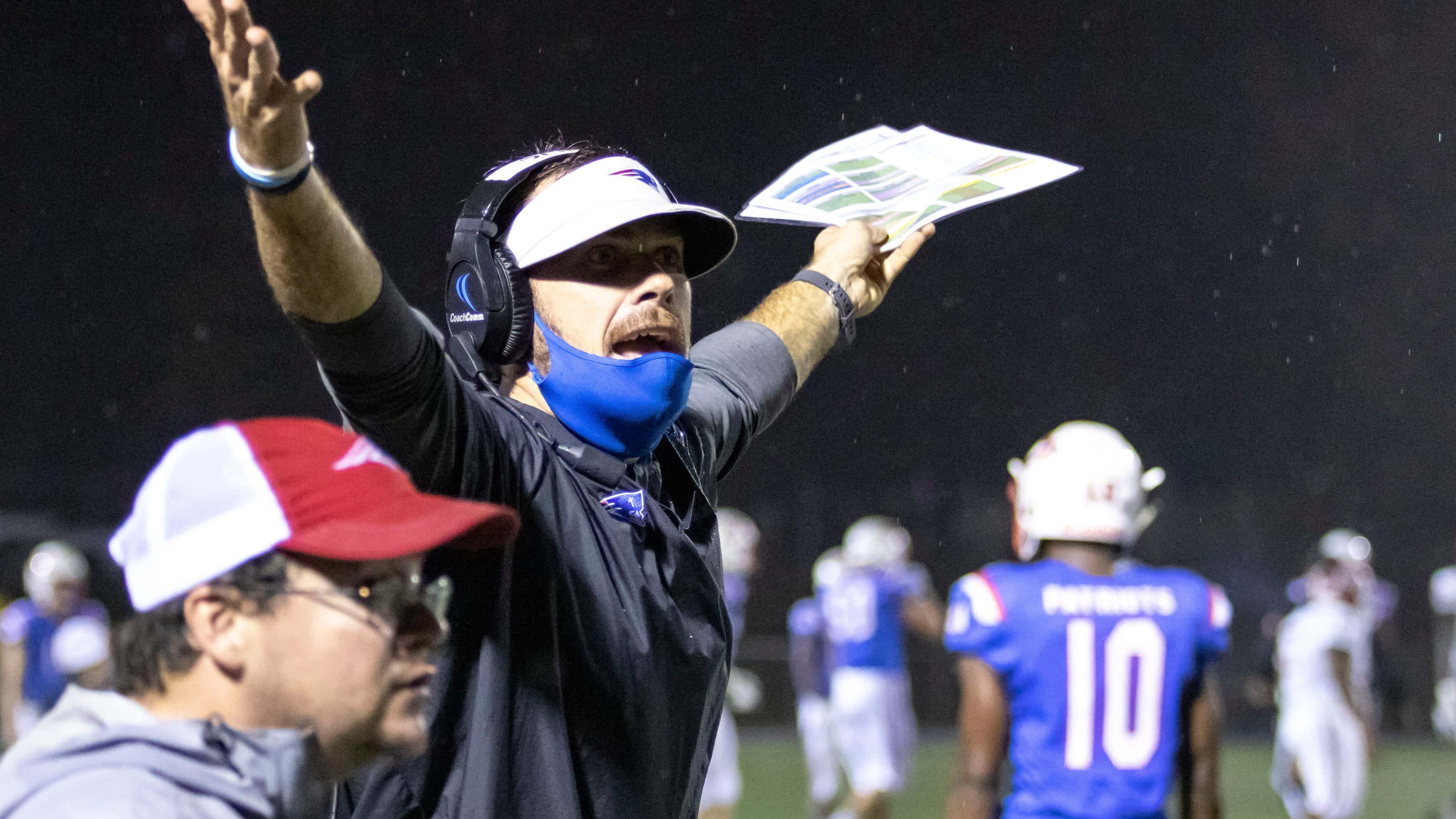 Football Coach 桌布 壁紙 — 一位足球教練在夜間球場燈光下拿著戰術板大聲下達指令。