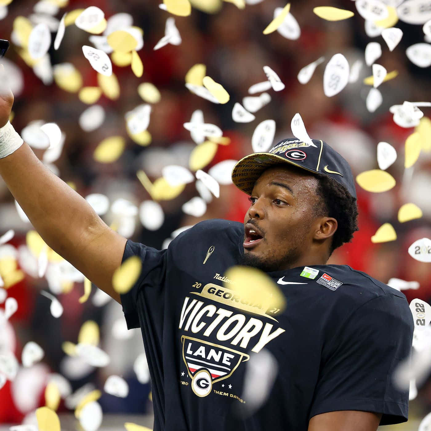  壁紙 — 一名穿著Georgia Victory Lane襯衫的足球運動員在周圍飄落的五彩紙屑中慶祝。