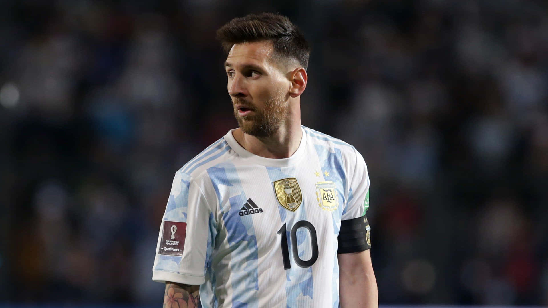 Messi 2022 桌布 壁紙 — 阿根廷足球巨星利昂內爾·梅西身穿標誌性的10號球衣，在球場燈光下的夜間比賽中專注地站立。