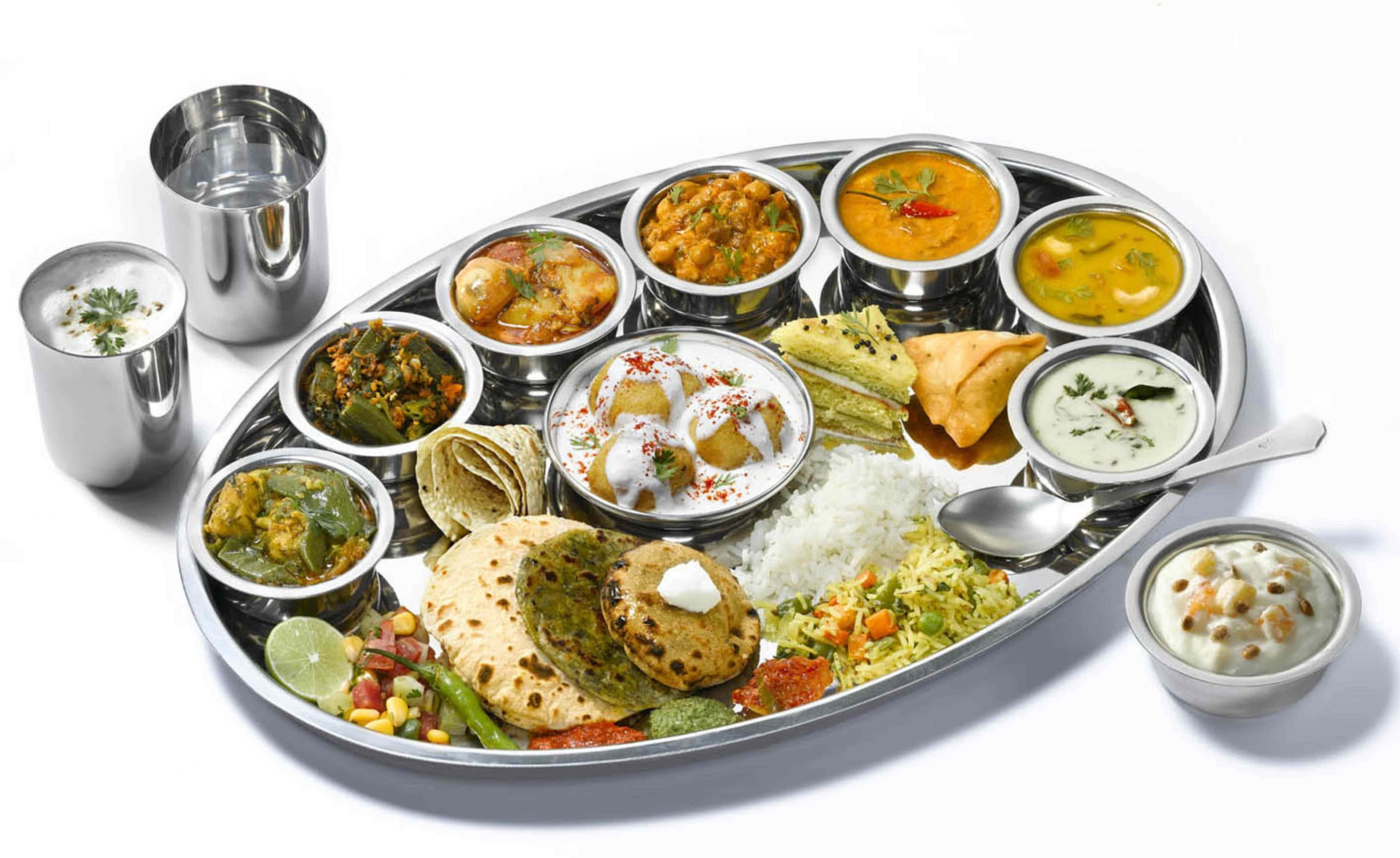 Thali 桌布 壁紙 — 一個閃亮的金屬塔利盤，盛滿色彩繽紛的印度咖哩、烤餅、米飯和酸辣醬，為一場充滿活力的盛宴而擺設。