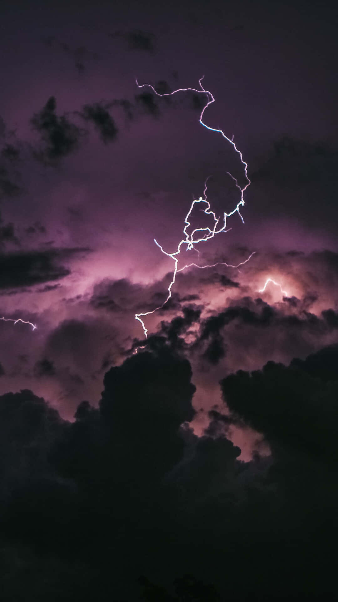 Lightning iPhone 桌布 壁紙 — 一道鋸齒狀閃電穿過充滿烏雲的紫色暴風雨天空，形成分叉。