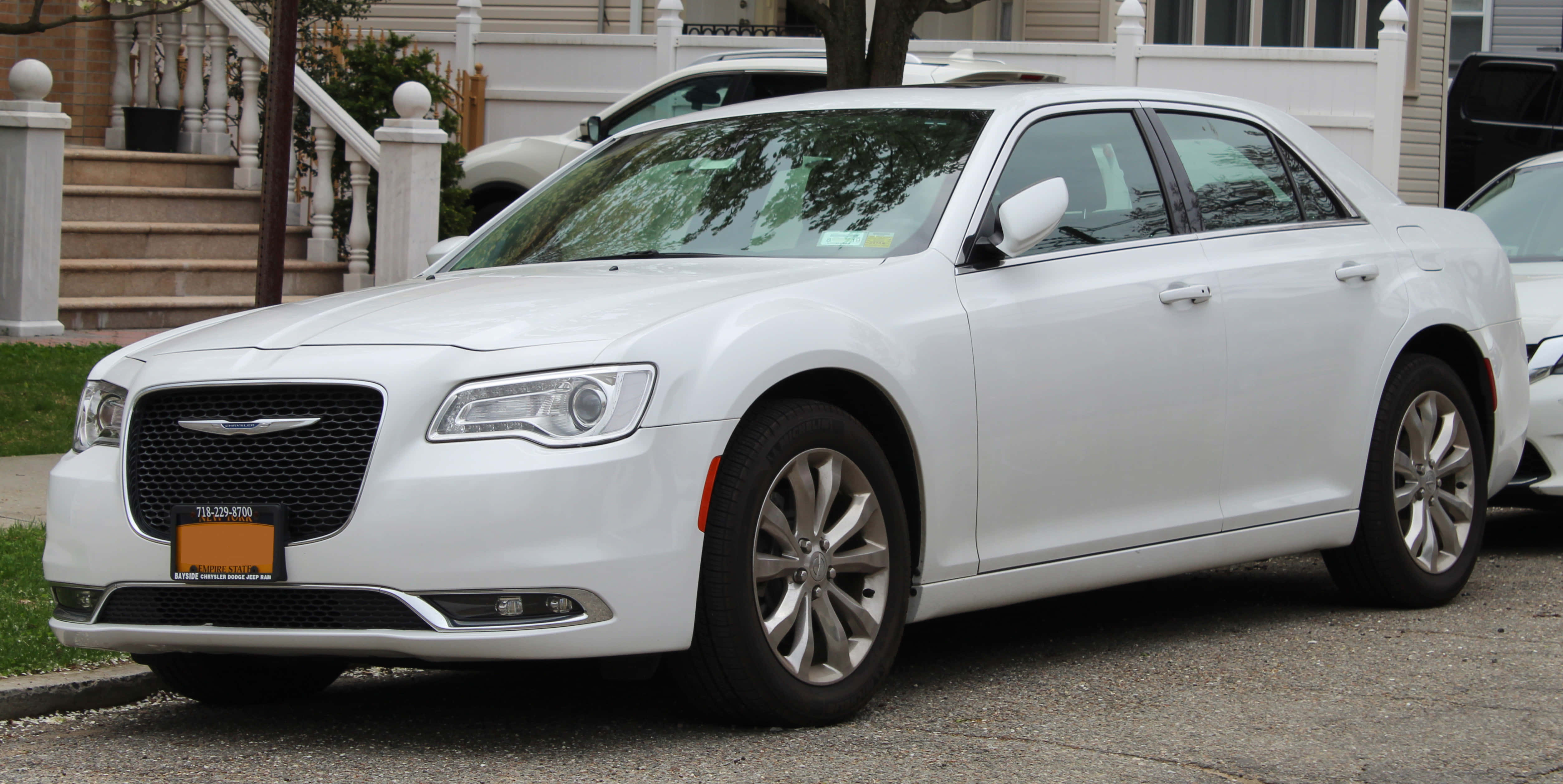 Chrysler 300 桌布 壁紙 — 一輛純白色的克萊斯勒轎車停放在住宅街道上，背景有房子和樓梯。