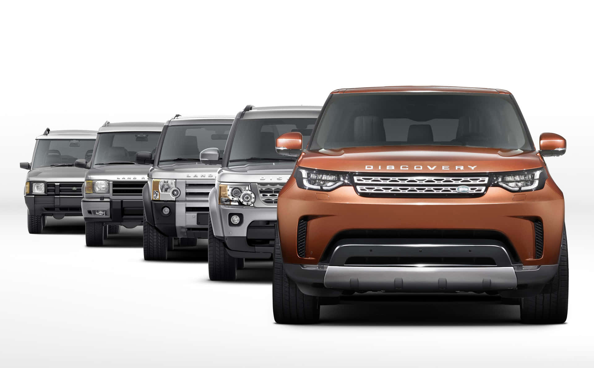 Land Rover Discovery 桌布 壁紙 — 一系列金屬色調的 Land Rover Discovery SUV 從前到後排列在乾淨的白色背景上。