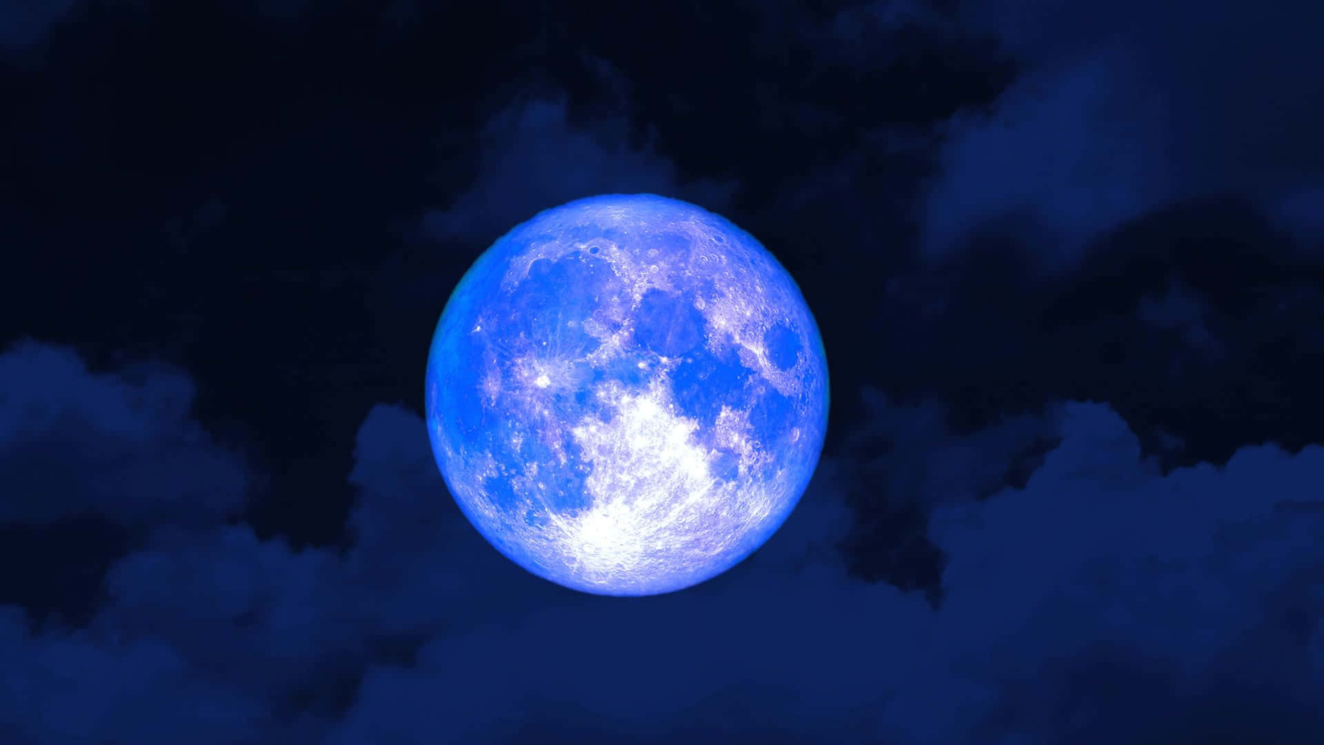  壁紙 — 一輪明亮的藍月在深邃的夜空中穿過烏雲發出光芒。