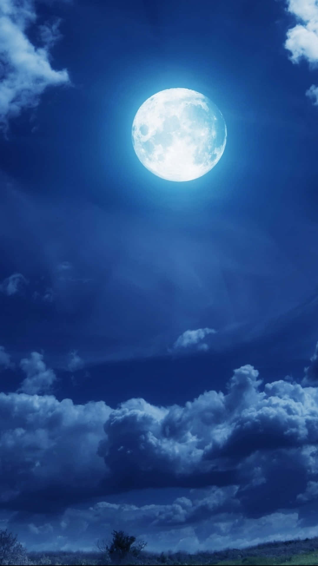  壁紙 — 一輪明亮的滿月在深藍色夜空中的紋理雲層中閃耀。