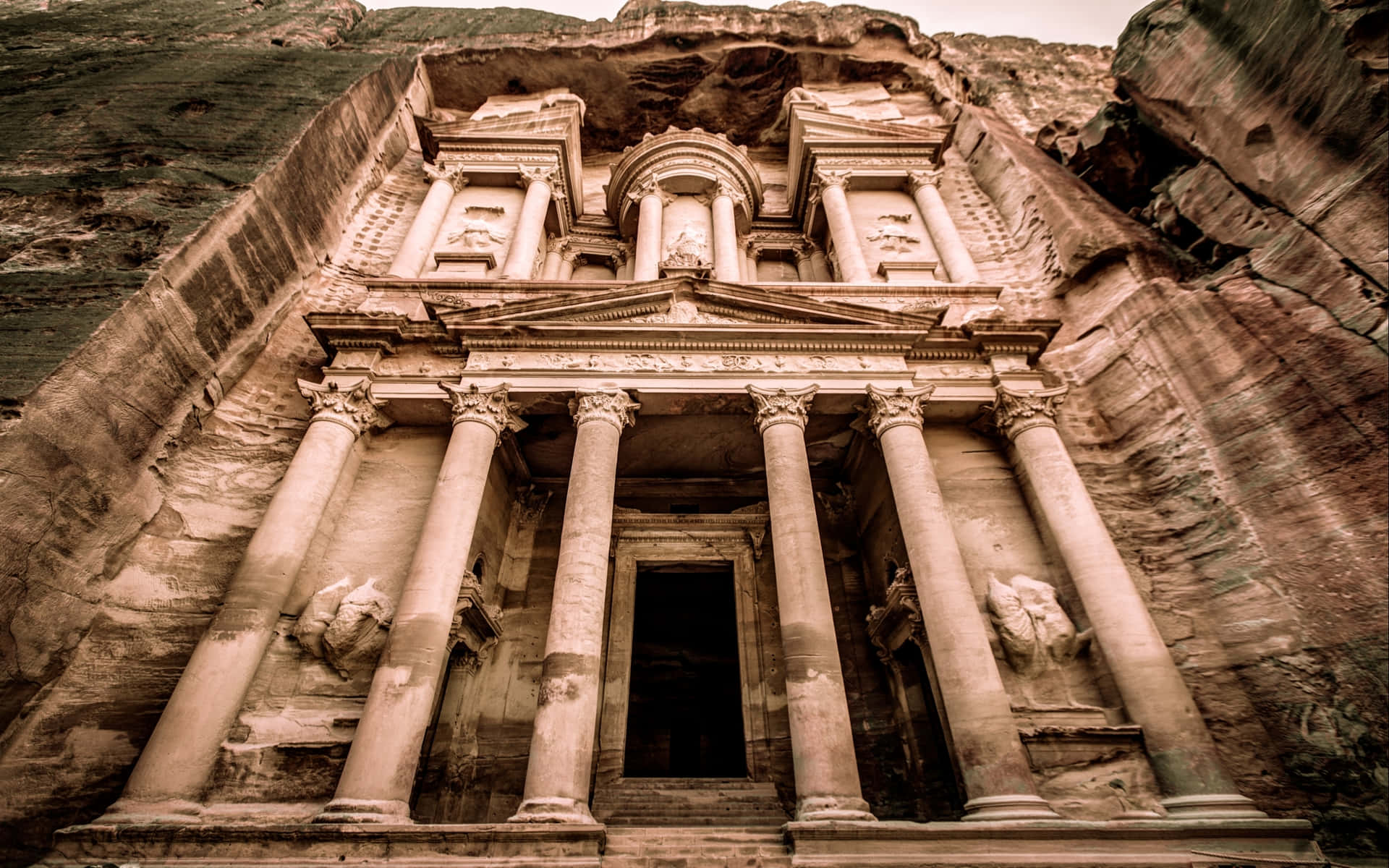 古老的雕刻寺廟，柱子嵌入砂岩懸崖 — Jordan 壁紙
