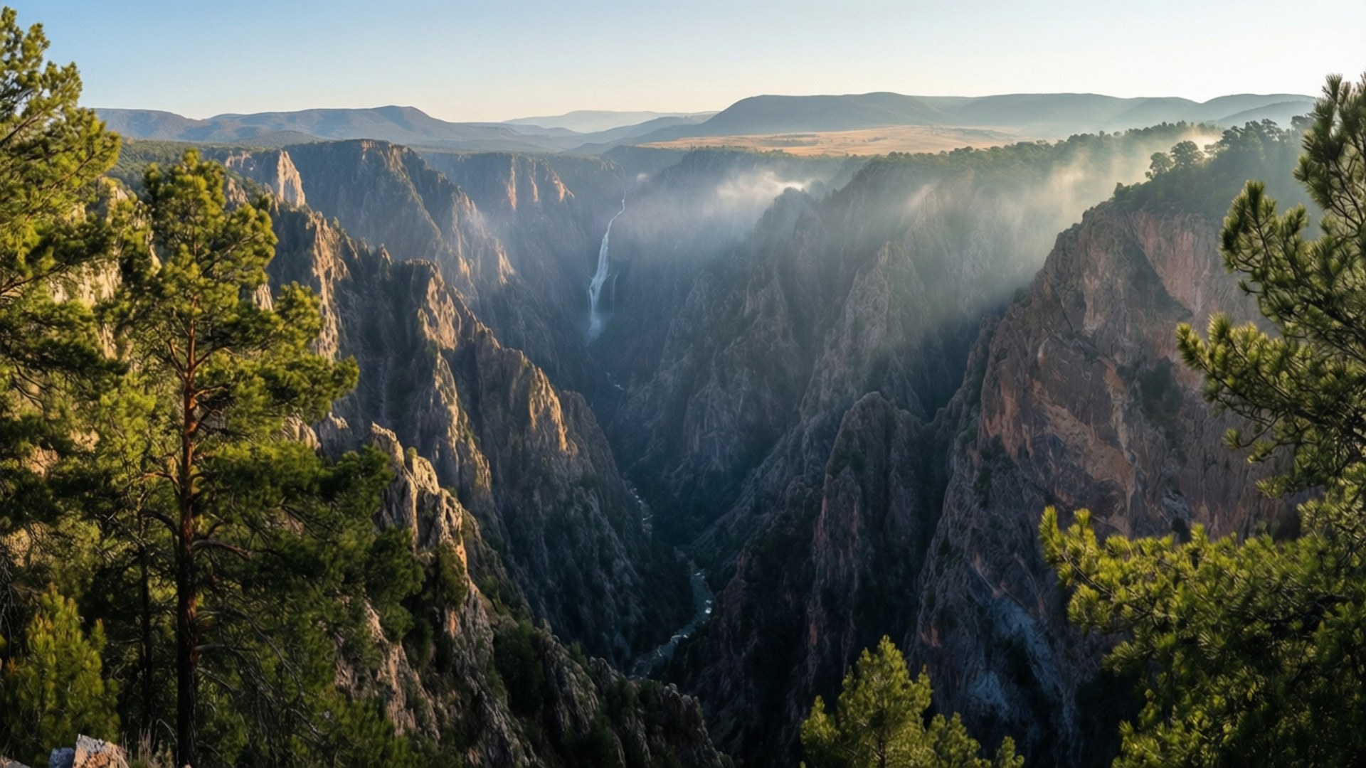 Copper Canyon Panorama 壁紙 — 一個雄偉的峽谷，擁有陡峭的岩石懸崖和日出時籠罩在薄霧中的層疊瀑布。