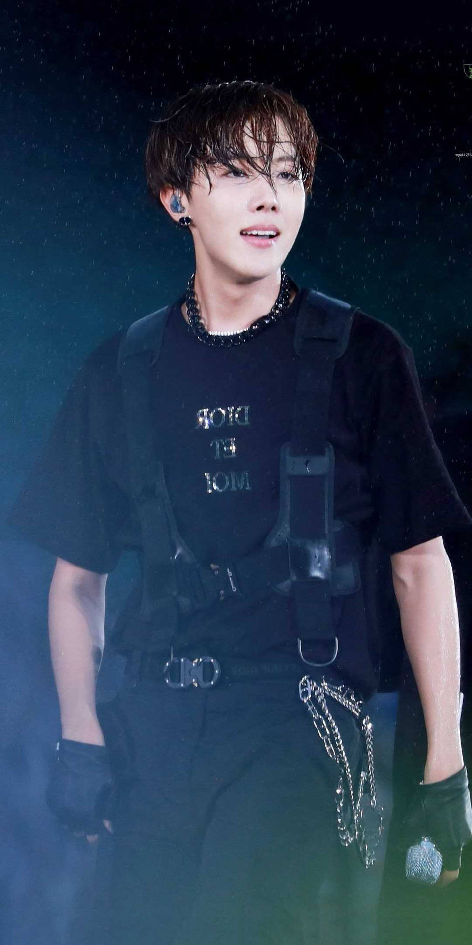 K-pop表演者在雨中表演時，身穿黑色舞台服裝，在發光的燈光下。 — Bts 壁紙