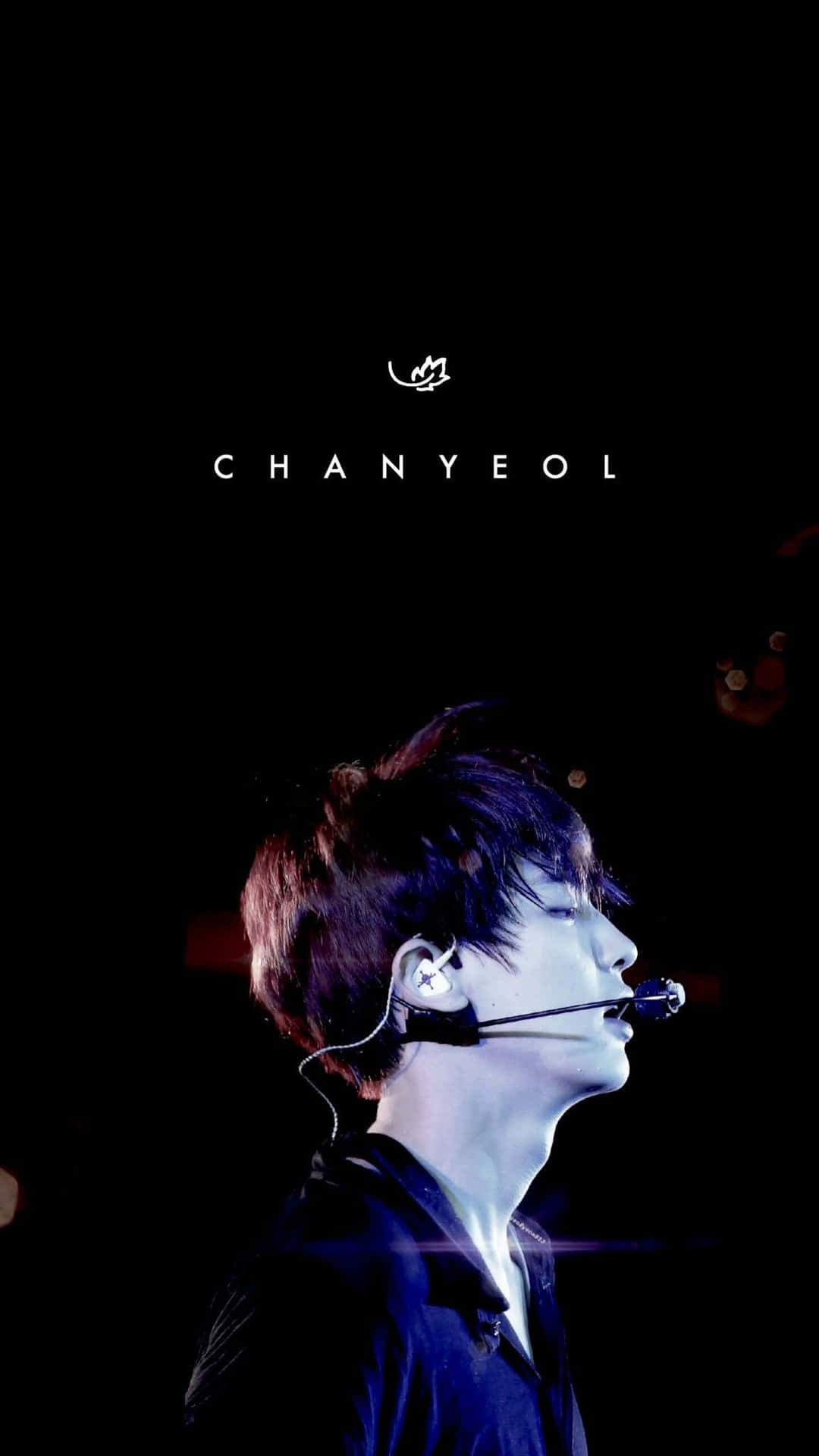K-pop 歌手 Chanyeol 戴著麥克風耳機在舞台上表演。 — K Pop 壁紙