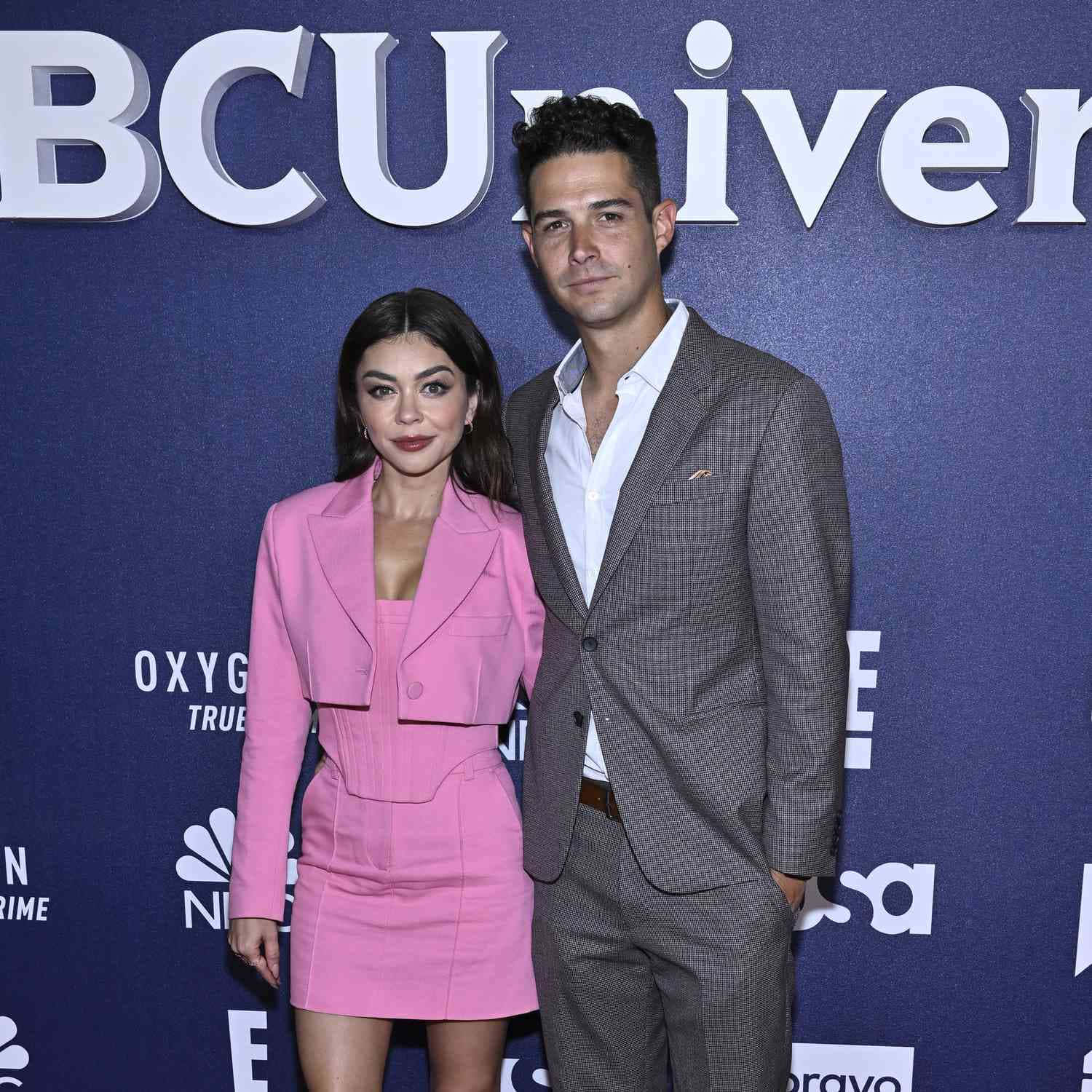 Sarah Hyland 桌布 壁紙 — 一名男子和一名女子在媒體活動中，在帶有標誌的藍色背景前合影。