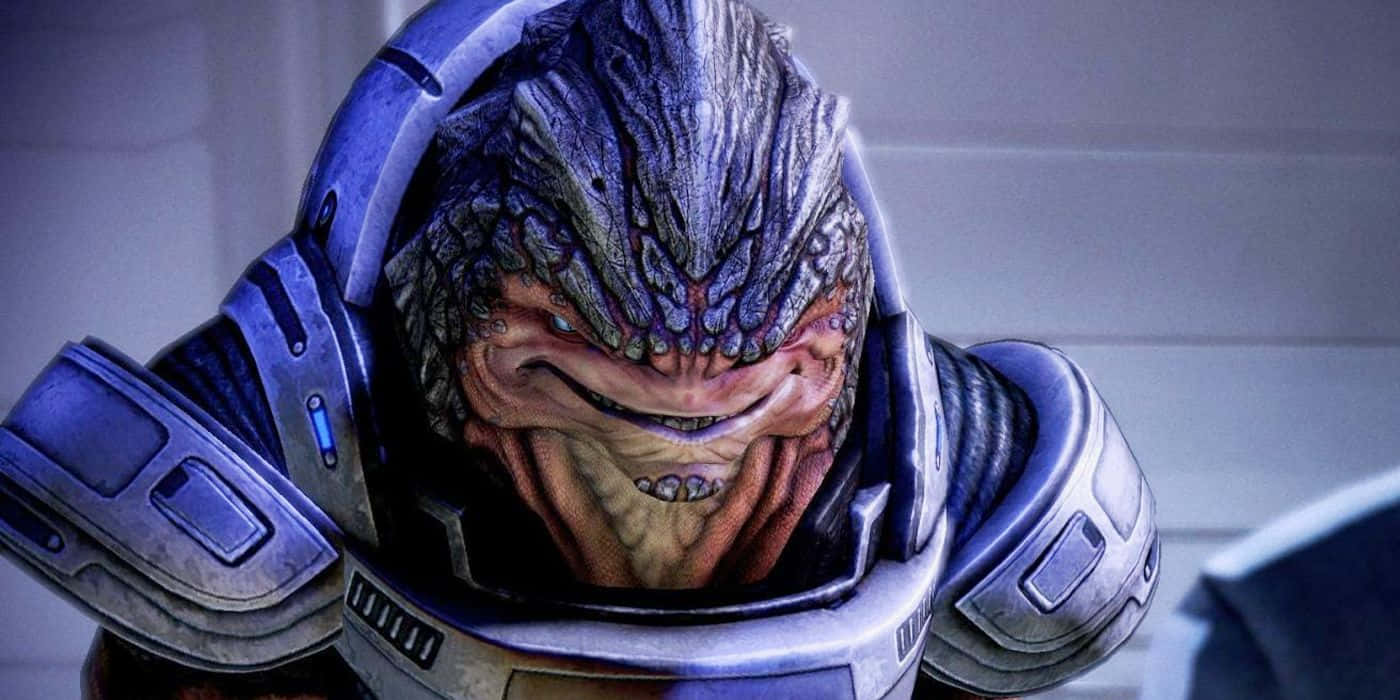 Mass Effect Grunt 桌布 壁紙 — 一個身穿藍銀盔甲、頭部有紋理鱗片和尖牙的威脅性外星戰士，正凝視著。