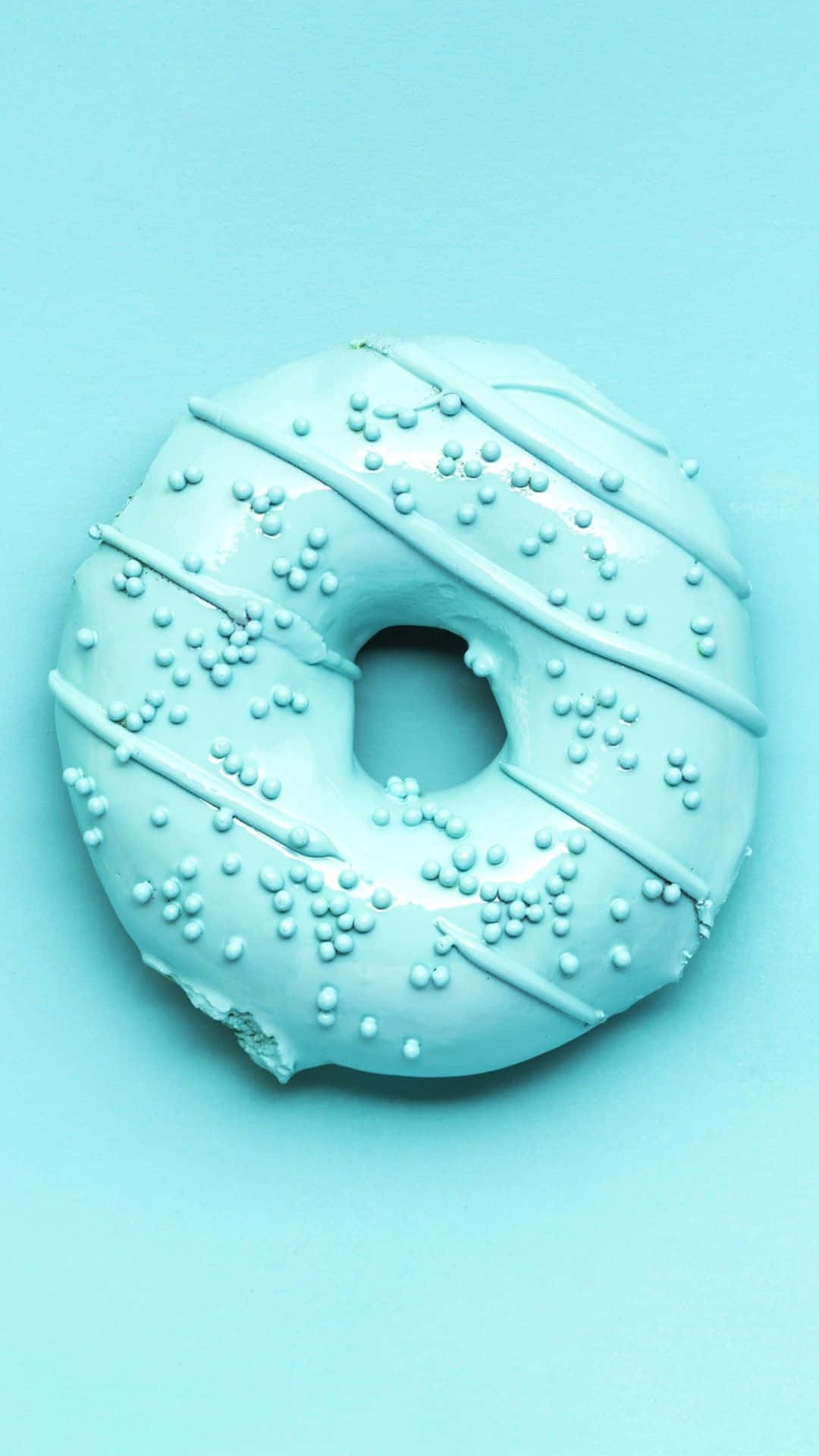 Turquoise Blue 桌布 壁紙 — 一個薄荷綠色糖霜甜甜圈，配上相配的彩色糖粒，位於純色薄荷背景中央。