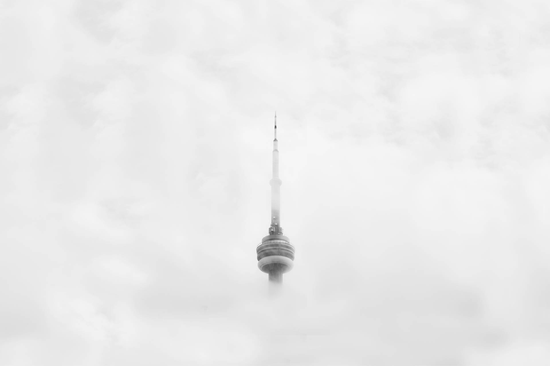 CN 塔在灰色天空中從雲層中浮現。 — 酷 NBA 壁紙
