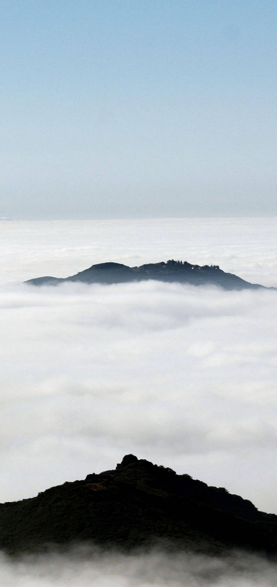 山峰聳立於雲海之上，藍天清澈 — iPhone X 壁紙